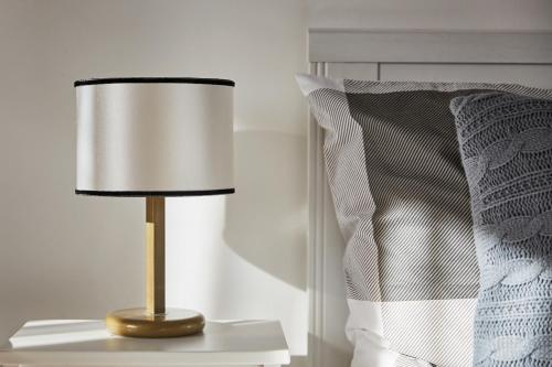 a lamp sitting on a table next to a bed at Szarka Vendégház és Pince in Mád