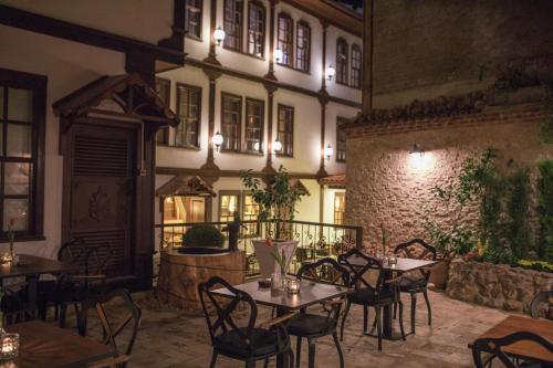 BAYEZİD HAN KONAK في أماصيا: مطعم فيه طاولات وكراسي امام مبنى
