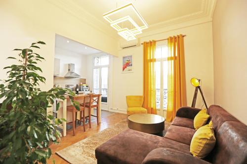 a living room with a brown couch and a kitchen at Splendid apart in the heart of Nice in Nice
