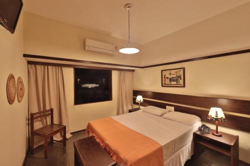 a hotel room with a bed and a chair at Hotel Pousada São Francisco in Olinda