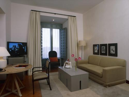 a living room with a couch and a table at Parador de La Granja in La Granja de San Ildefonso