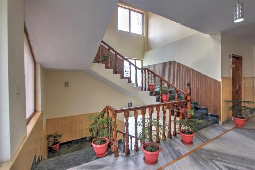 a staircase with potted plants in a building at Hotel Mountain face by Snow City Hotels in Manāli