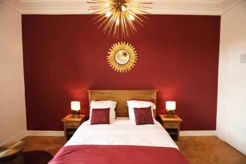 une chambre avec un grand lit avec un mur rouge dans l'établissement Splendid apart in the heart of Nice, à Nice