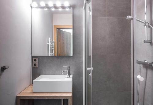 a bathroom with a sink and a shower with a mirror at Schima Drosa Apartments - Studios - by Pferd auf Wolke in Gaschurn