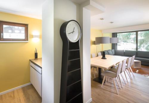 a clock on a wall next to a dining room at Schima Drosa Apartments - Studios - by Pferd auf Wolke in Gaschurn