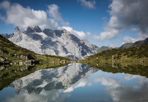 a mountain reflecting in a lake in front of it at Schima Drosa Apartments - Studios - by Pferd auf Wolke in Gaschurn