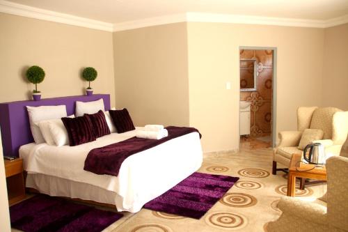a bedroom with a large bed with a purple headboard at Rehoboth Mountain Suites in Mbabane