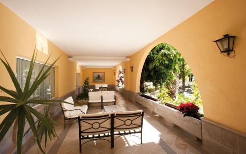 a hallway with a table and chairs and a large window at Palm Oasis Maspalomas in Maspalomas