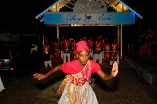 a woman dancing in front of a group of people at Village Creole in Les Trois-Îlets