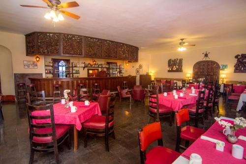 a restaurant with pink tables and chairs in a room at Hotel Playa de Cortes in Guaymas