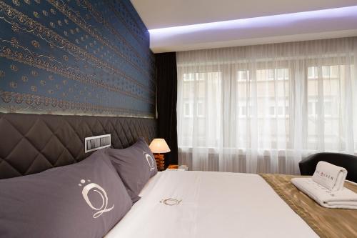 a bedroom with a bed and a blue wall at The Queen Luxury Apartments - Villa Carlotta in Luxembourg