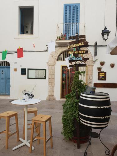 un edificio con una mesa y dos sillas y un barril en Orazio33 b&b, en Monopoli
