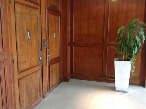 a potted plant sitting in a hallway next to doors at Departamento Zona Puerto De Olivos in Olivos