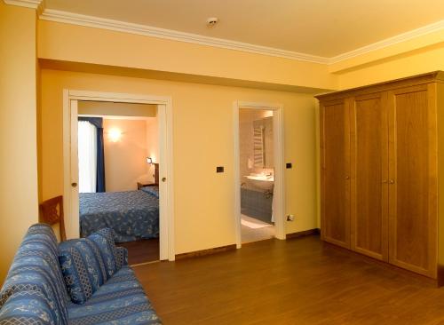 a living room with a couch and a bedroom at Albergo Costantini in Tarcento