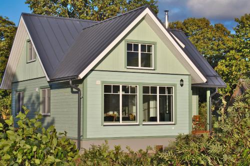 a small green house with a black roof at Holmi Maja in Haapsalu