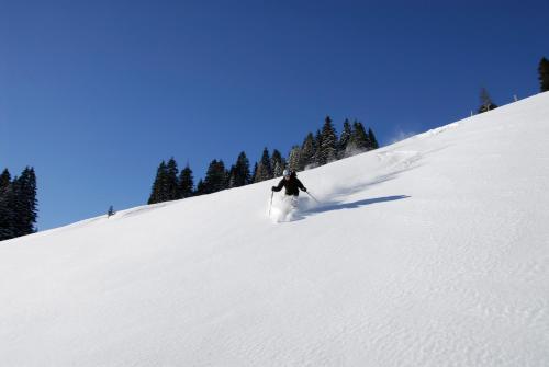 a person is skiing down a snow covered slope at Hotel Kraftquelle Schlossblick in Angerberg