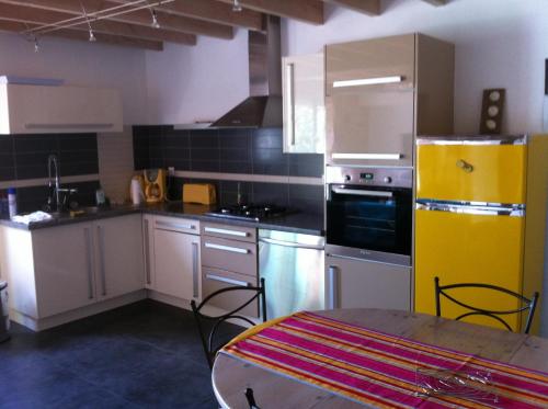 a kitchen with white cabinets and a yellow refrigerator at Gîte de la Collonge in Ambierle