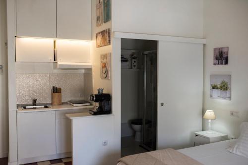 a white kitchen with a sink and a microwave at Suite Plaza de la Laguna by Dulce in Ayamonte