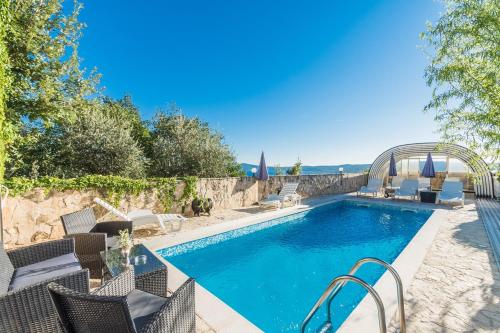 a swimming pool with chairs next to a resort at Apartment Crikvenica 7 in Crikvenica