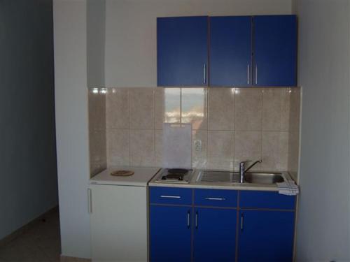 a kitchen with blue cabinets and a sink at Apartmani Lekovic Sutomore in Sutomore