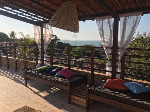 a porch with two beds and a view of the ocean at Pousada Mar e Sol in Pipa