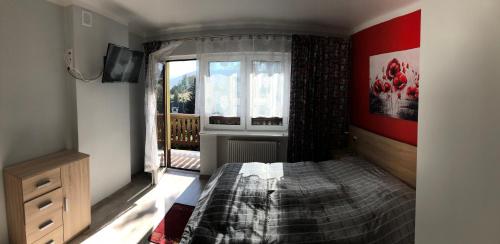 a bedroom with a bed and a window at SOWA apartamenty in Ustroń