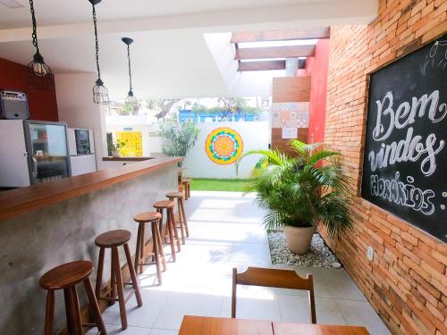 Un bar con taburetes de madera y una pared de ladrillos. en Guest House Cabo Frio, en Cabo Frío