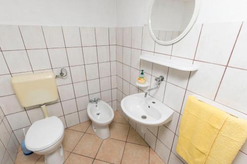 bagno bianco con servizi igienici e lavandino di House Svjetlana a Postira (Postire)