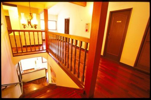 a view of a hallway with a staircase and a door at Pension Candytuft in Karuizawa