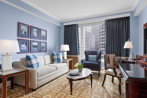 a living room with a couch and a chair at Boston Harbor Hotel in Boston