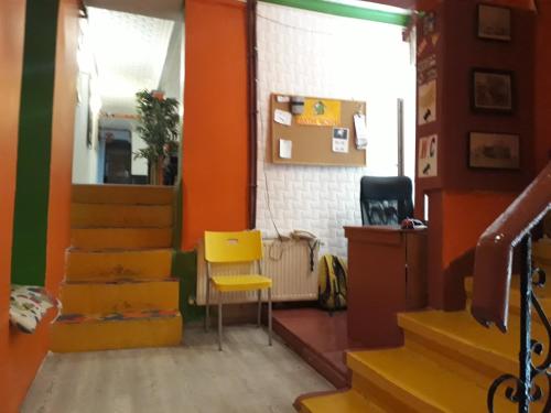 a room with orange walls and a yellow chair at TAXİM HOSTEL in Istanbul