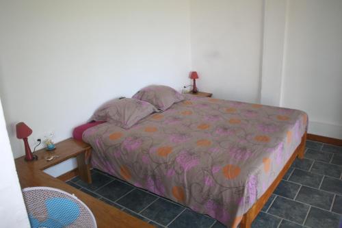 ein Schlafzimmer mit einem Bett und einem Tisch mit einem Nachttisch in der Unterkunft océan studio in Tevaitoa
