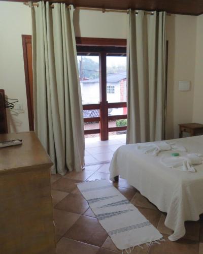 a bedroom with a bed and a sliding glass door at Estalagem São Gonçalo in Tarituba