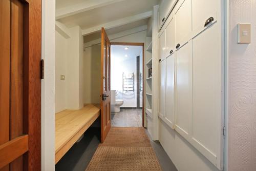 a hallway with a toilet and a door to a bathroom at O Naturel Vineyard Stay in Cromwell