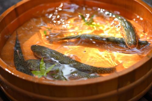 a bowl of soup with three fish in it at Yamagataya in Kitakata