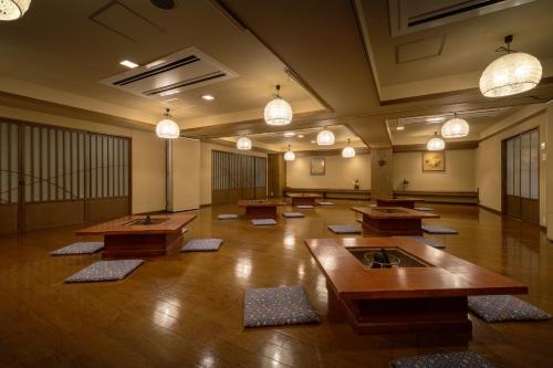 a large room with wooden tables and lights in it at Yamagataya in Kitakata