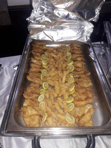 a pan of food with chicken in aluminum foil at E-Just Hotel Borg El Arab in Borg El Arab
