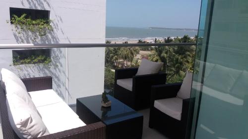 uma varanda com cadeiras e vista para o oceano em Cartagena Beach Condo - 1400 sq. Ft. (130 m2) em Cartagena de Indias