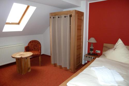 ein Schlafzimmer mit einem Bett, einem Stuhl und einem Fenster in der Unterkunft Hotel Goldener Stern in Frauenstein