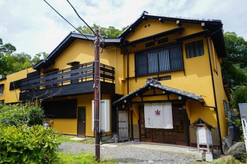 a yellow house with a pole in front of it at Onsen Yado Mizuguchi in Izu