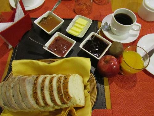 a table with a plate of bread and apples and a cup of coffee at Patagonia Swiss House in Puerto Natales