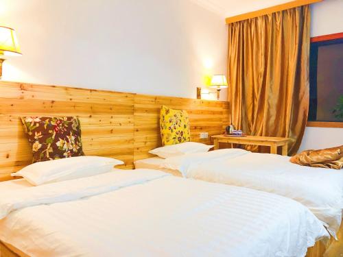 a hotel room with two beds and a window at Lakeside Inn in Guilin