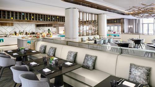 a restaurant with tables and chairs and a bar at Cordis, Beijing Capital Airport By Langham Hospitality Group in Shunyi