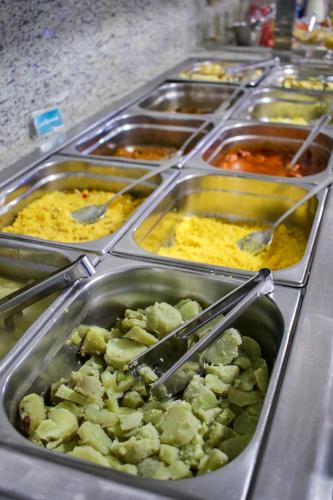 a buffet line of trays of food with ingrediants at Oriental Praia Hotel in João Pessoa