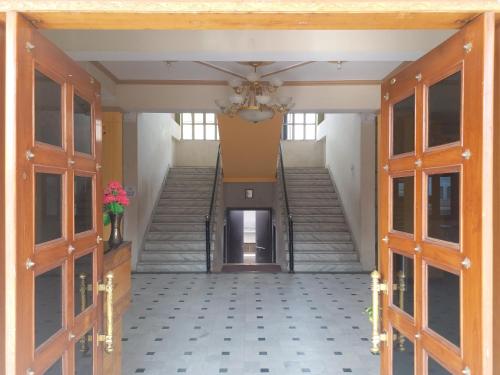 a hallway with stairs and doors with a vase of flowers at Hotel Narayan Palace in Amarsar
