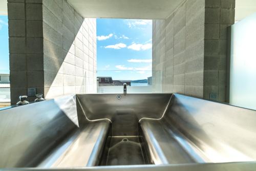 a large metal tub in a room with a window at Sacred Waters Taupo in Taupo
