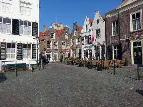 a cobblestone street in a city with buildings at Gastenverblijf Oostdijk in Goedereede