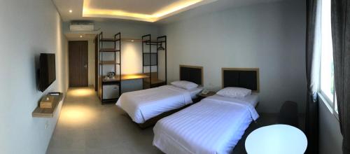 Un pat sau paturi într-o cameră la Hotel Arisu