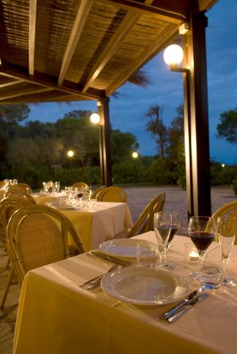a table with white plates and wine glasses on it at Roccamare Resort - Casa di Ponente in Castiglione della Pescaia
