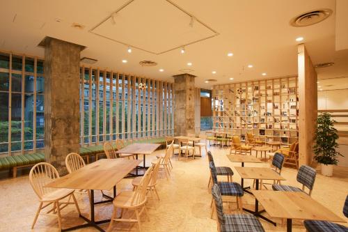 um restaurante com mesas e cadeiras de madeira e estantes em YUMORI ONSEN HOSTEL em Fukushima